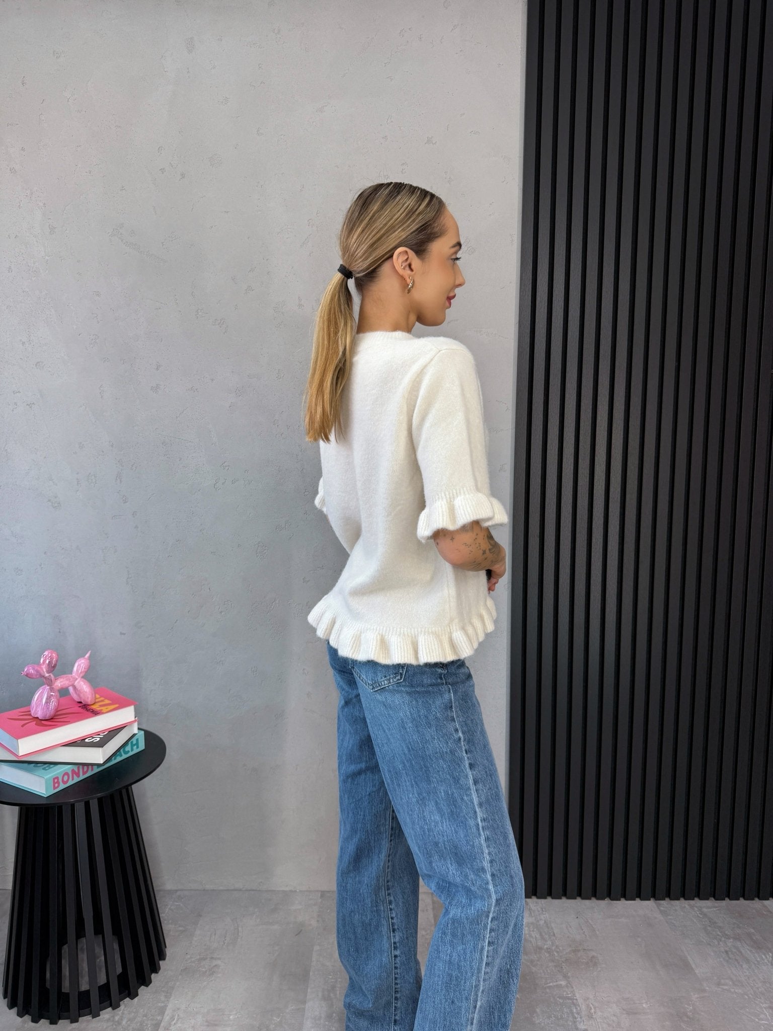 Apvalios iškirptės detalė – kreminis megztinis