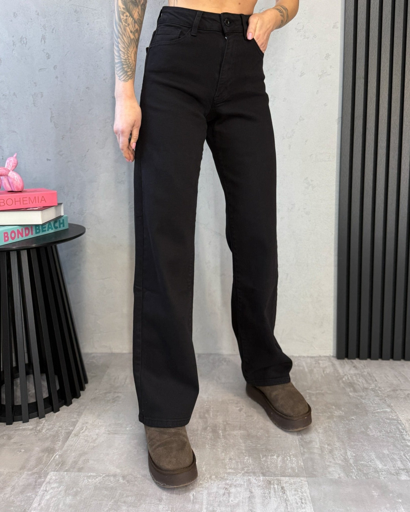 Juodų džinsų aukštas liemuo – sagutė ir užsegimas iš arti